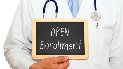 photo of a person holding a small chalkboard stating open enrollment